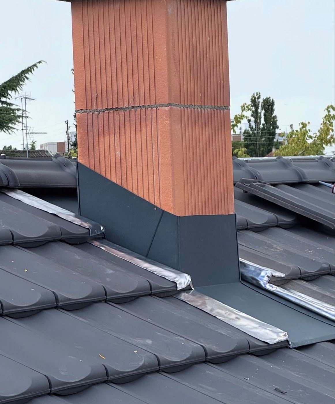 Saniertes Steildach mit neuer Kaminverkleidung – Arbeit von Alex Spenglerei